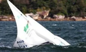 A white-sailed Hansa heeling hard in strong wind